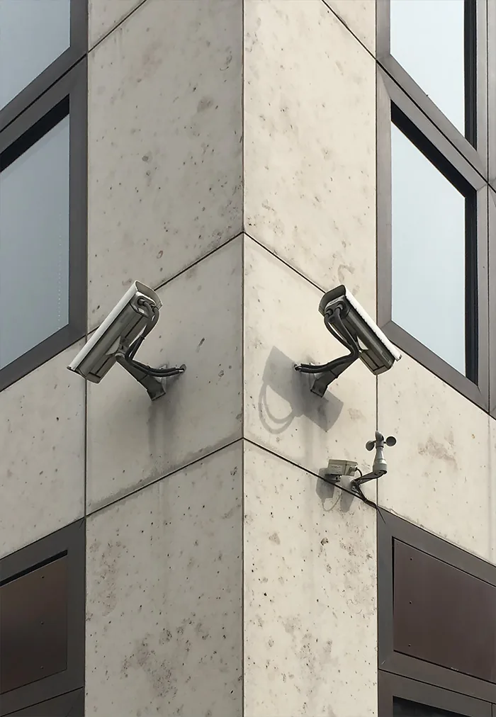 Two cameras on either side of a concrete building corner