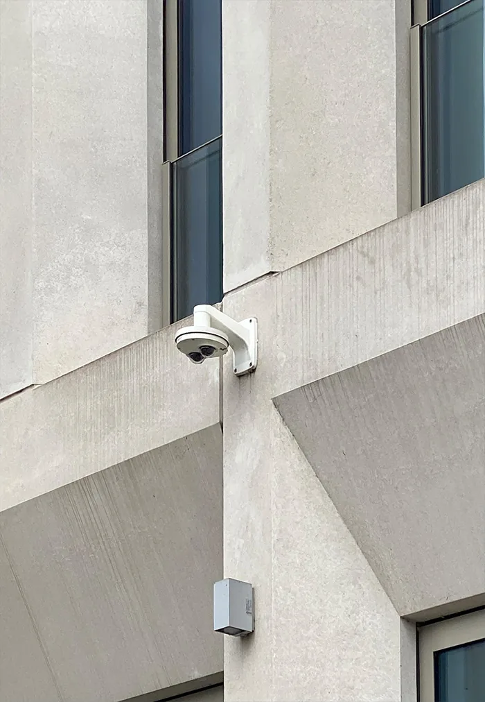 Camera on the corner of a pale concrete building with angled surfaces