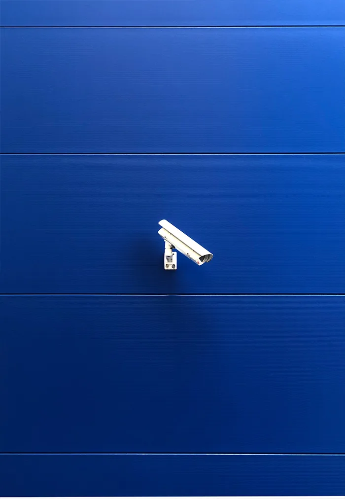 White camera on a deep blue facade